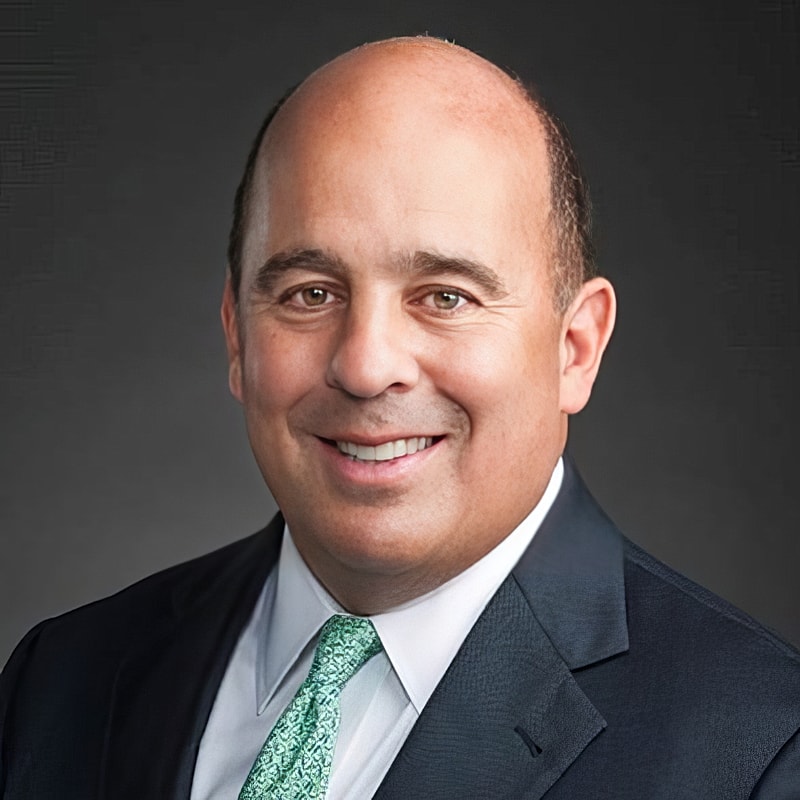 Professional headshot of a smiling man.